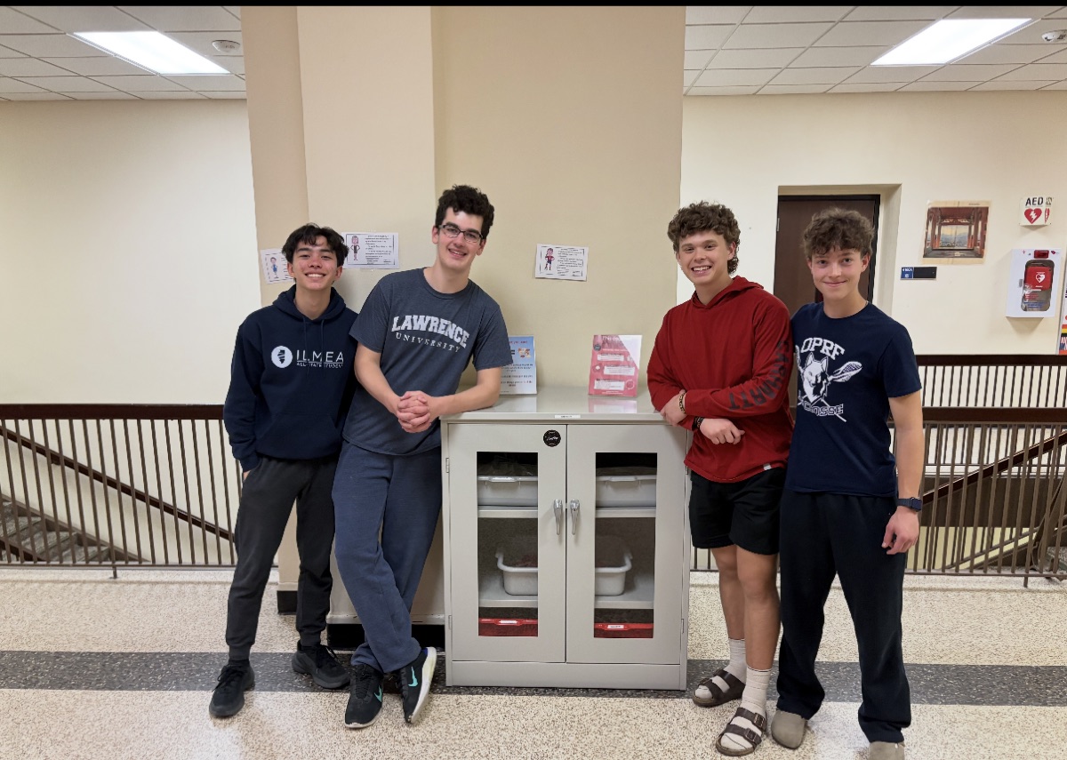 Four students standing with one of the snack cabinets in an OPRF hallway